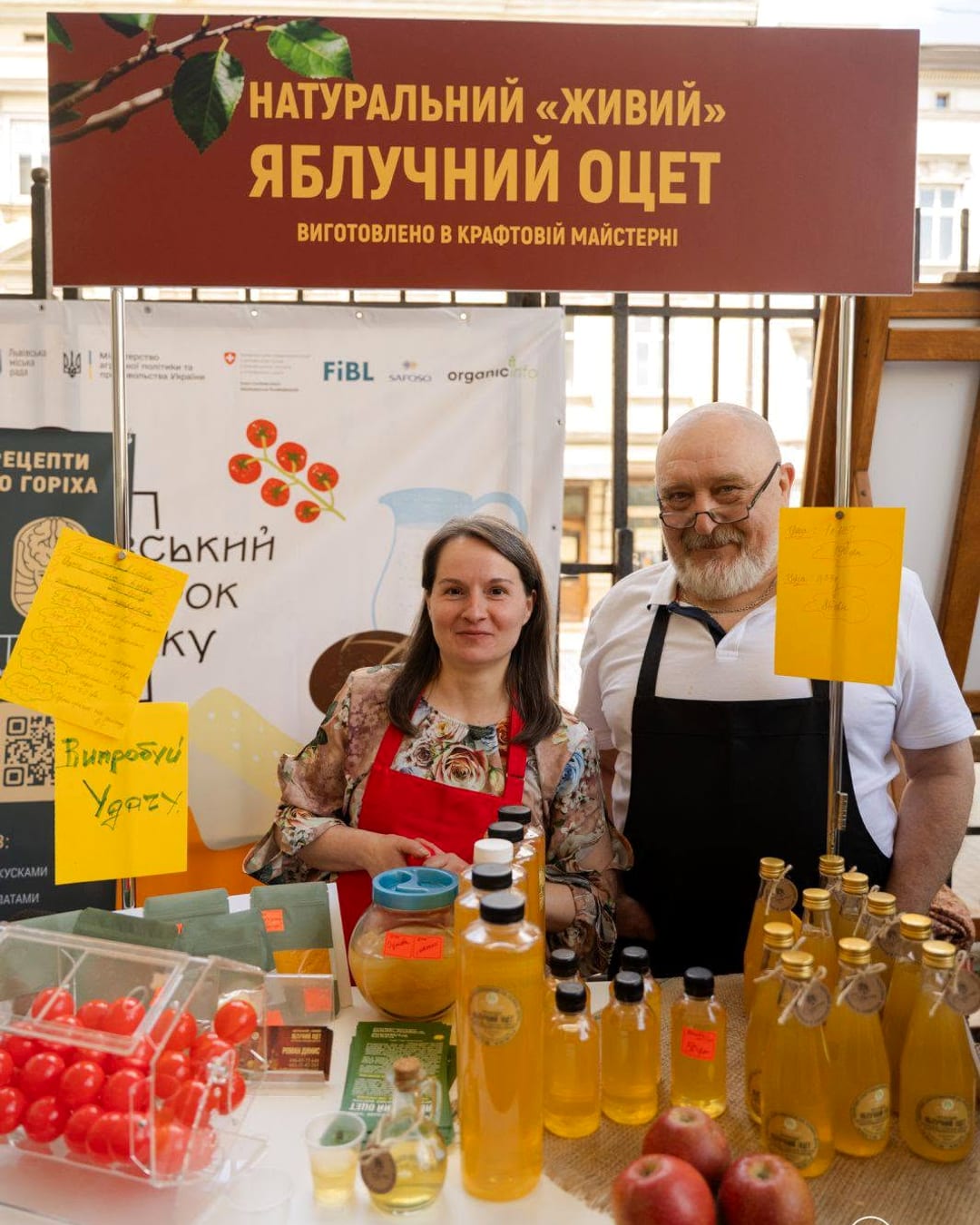 Стенд майстерні «Струмок» на Львівському ярмарку смаку: Роман за столом із пляшками оцту